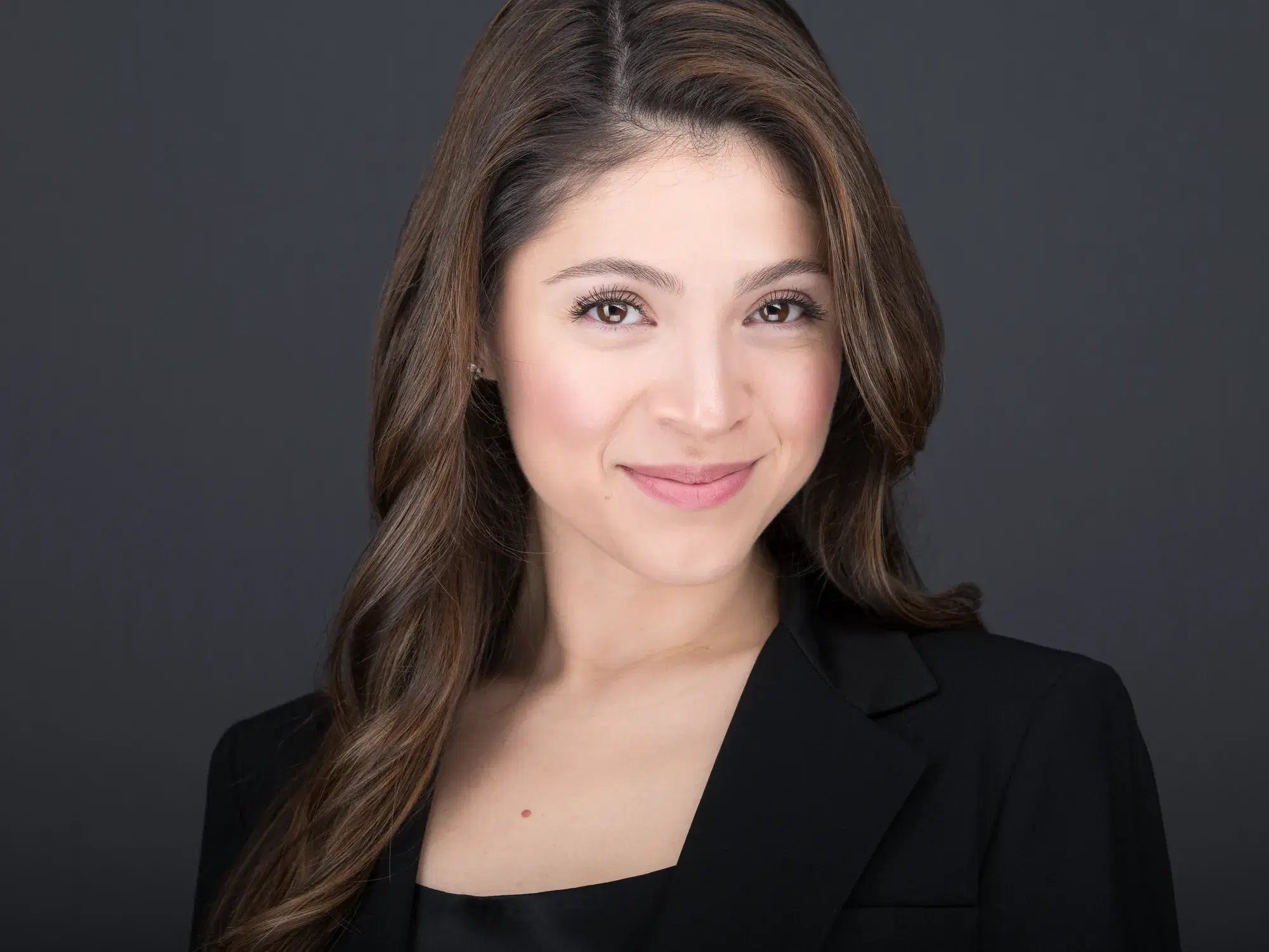 Woman with long brown hair and warm closed-mouth smile in black blazer — professional headshot by Damon Bates Photography, Sherborn MA