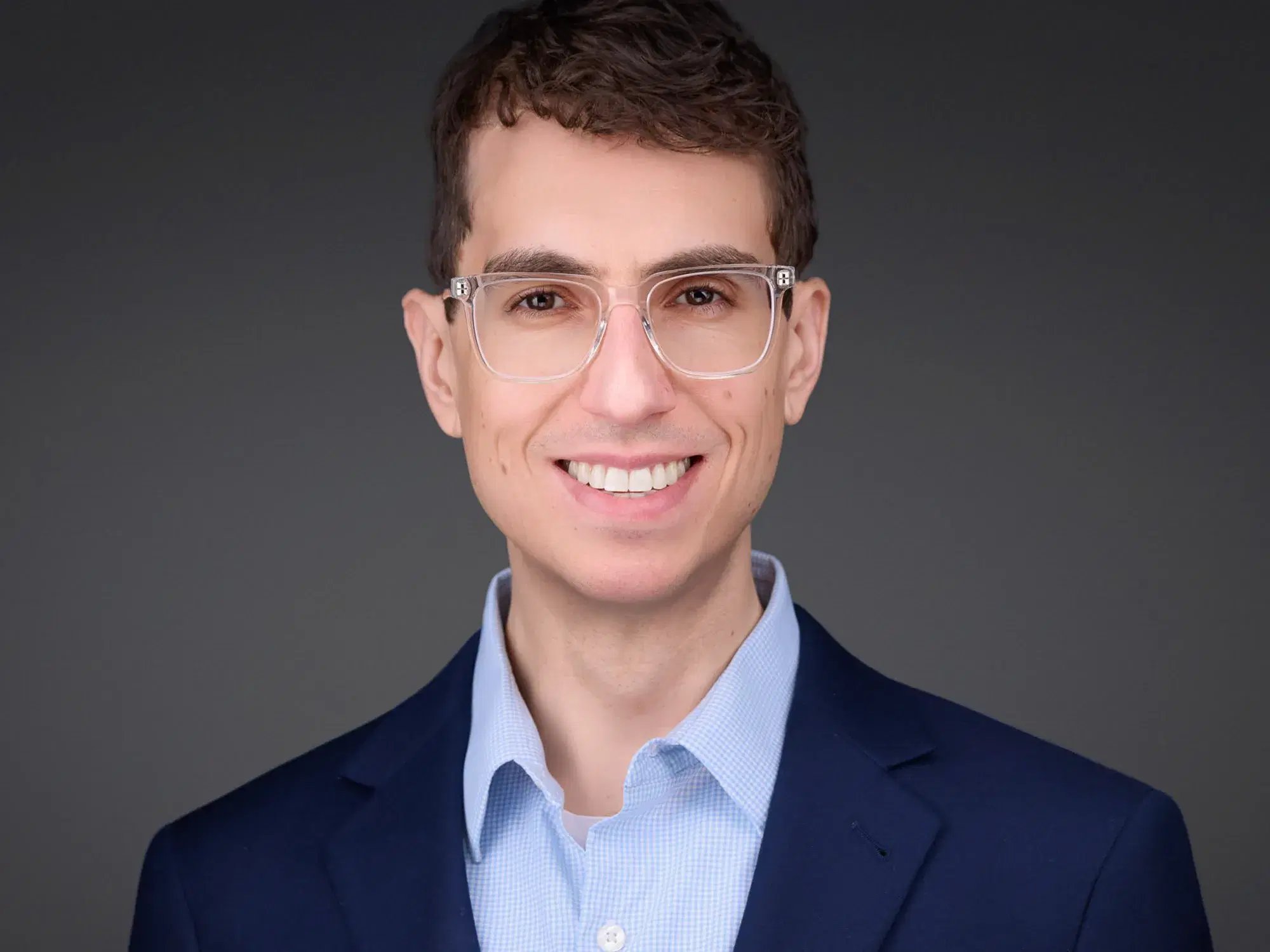 Corporate headshot of a man in a navy blazer and blue check shirt, on-location corporate headshot photography by Damon Bates