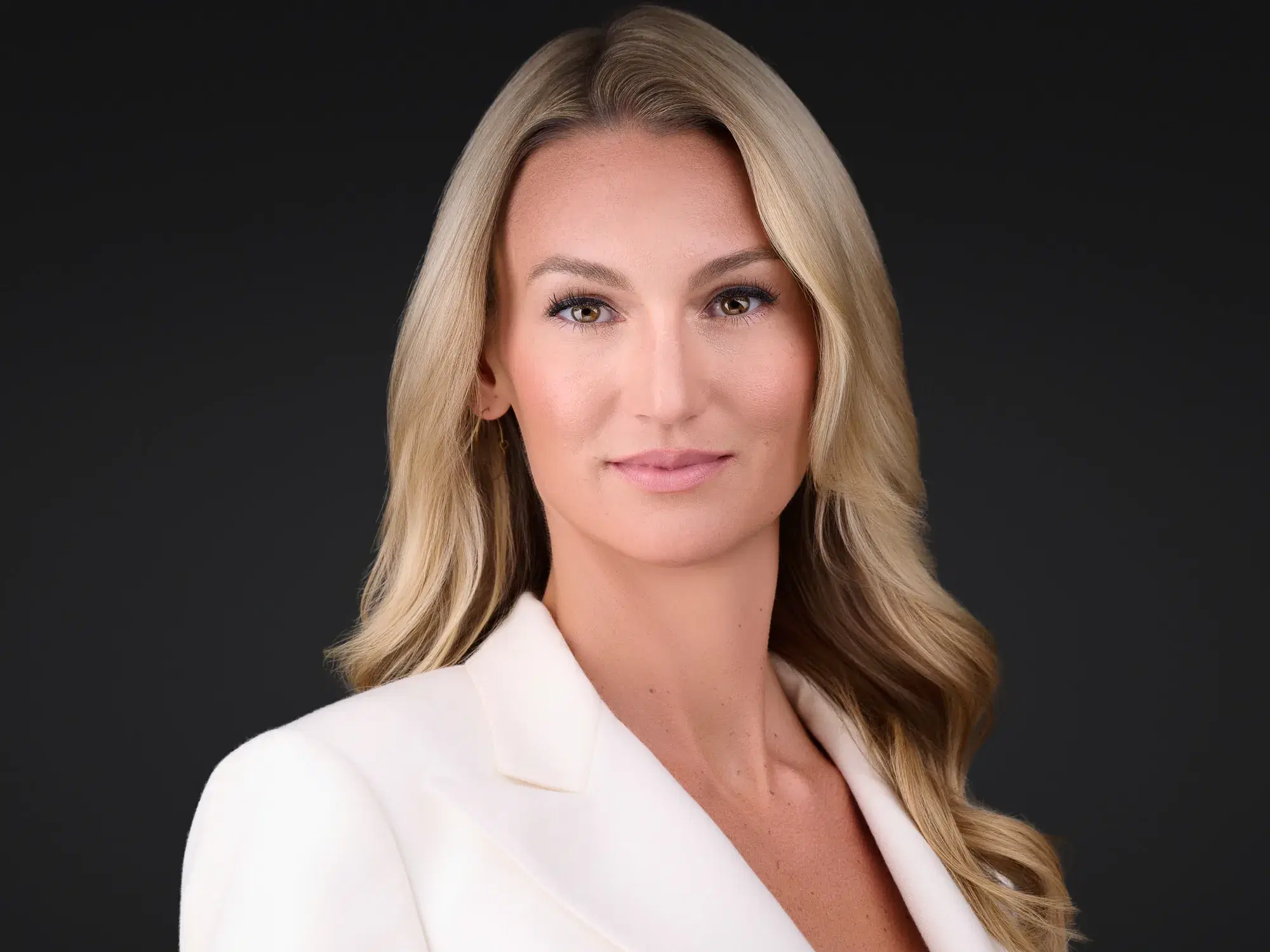 Corporate headshot of a woman in a cream blazer, a simple, neutral outfit that photographs well