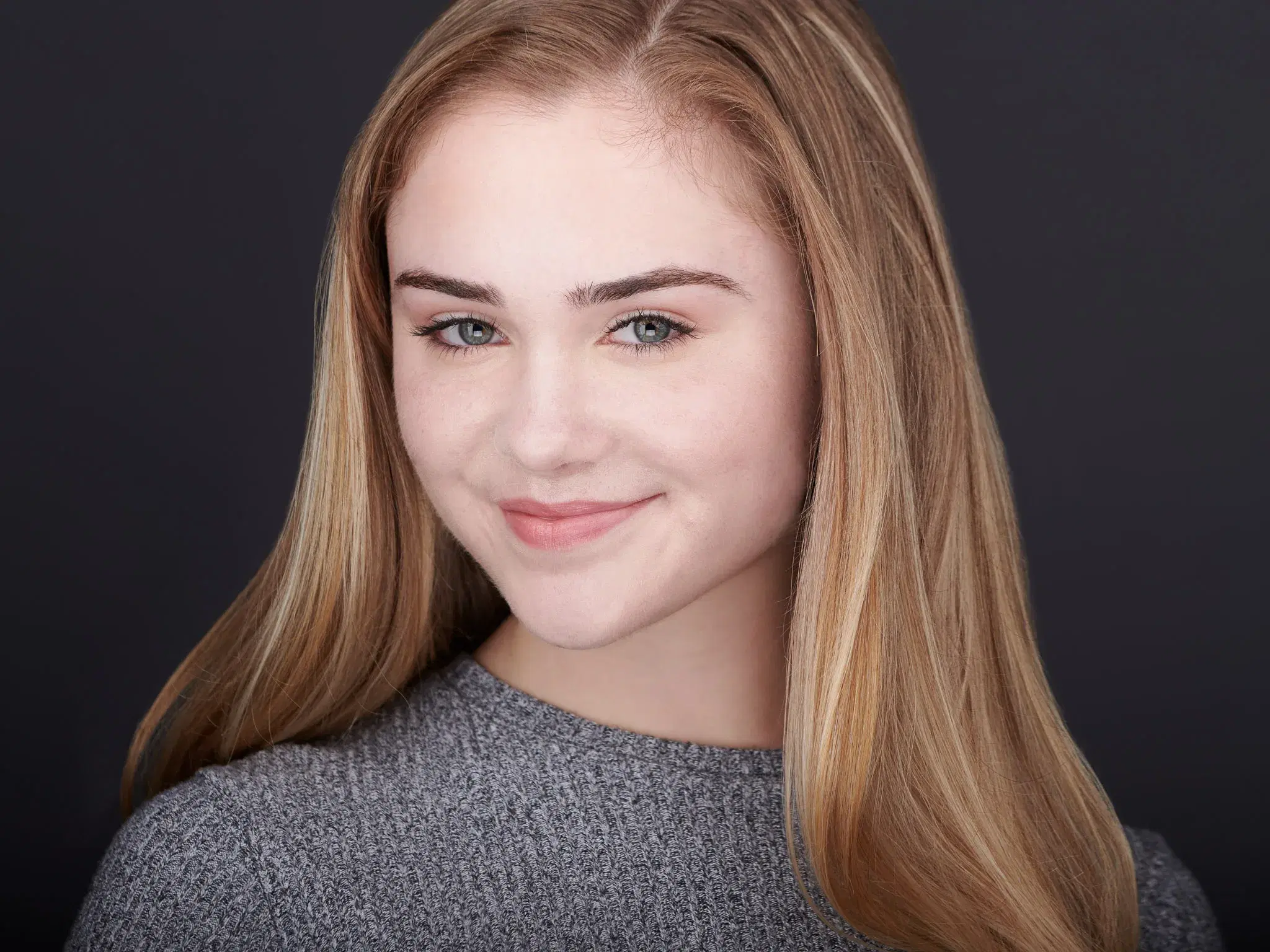 Young girl, blonde hair, grey sweater, smiling — child actor headshot by Damon Bates Photography, Sherborn MA
